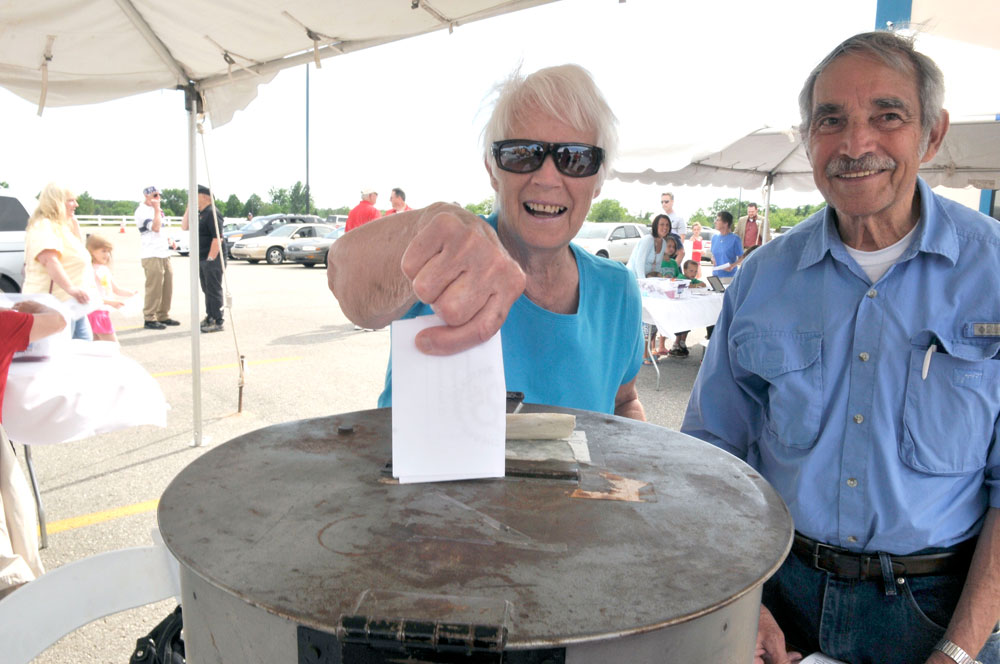 voting-annual-meeting-2014 woman putting ballot into ballot box while man smiles